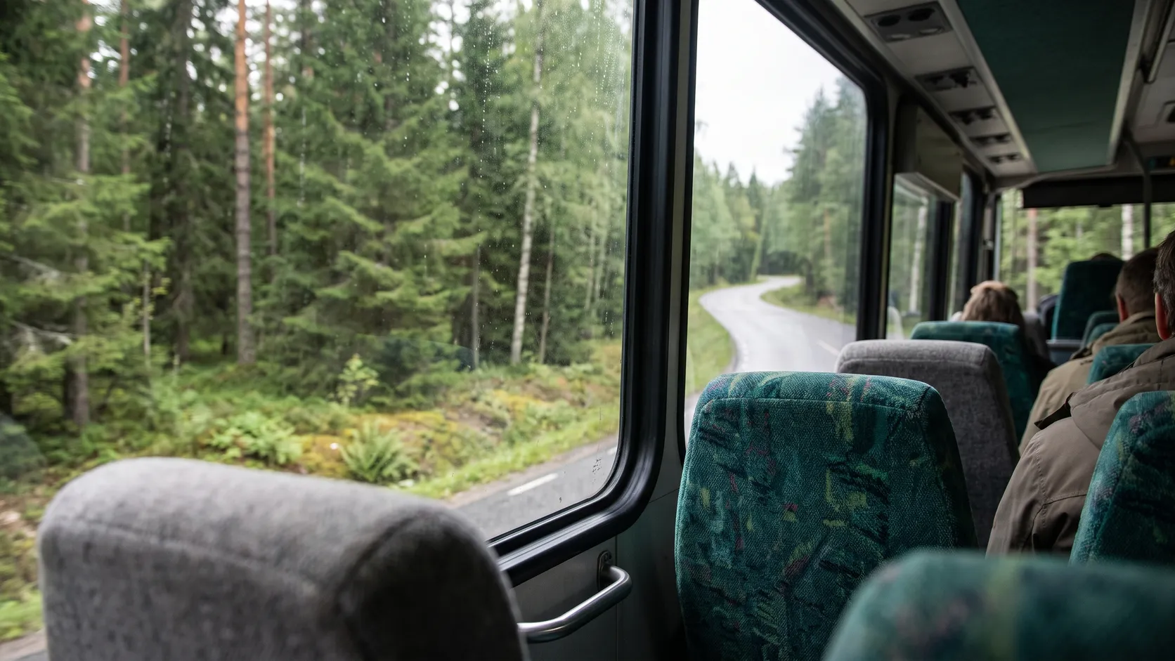 Utsikt från en regionbuss på väg genom skogen.